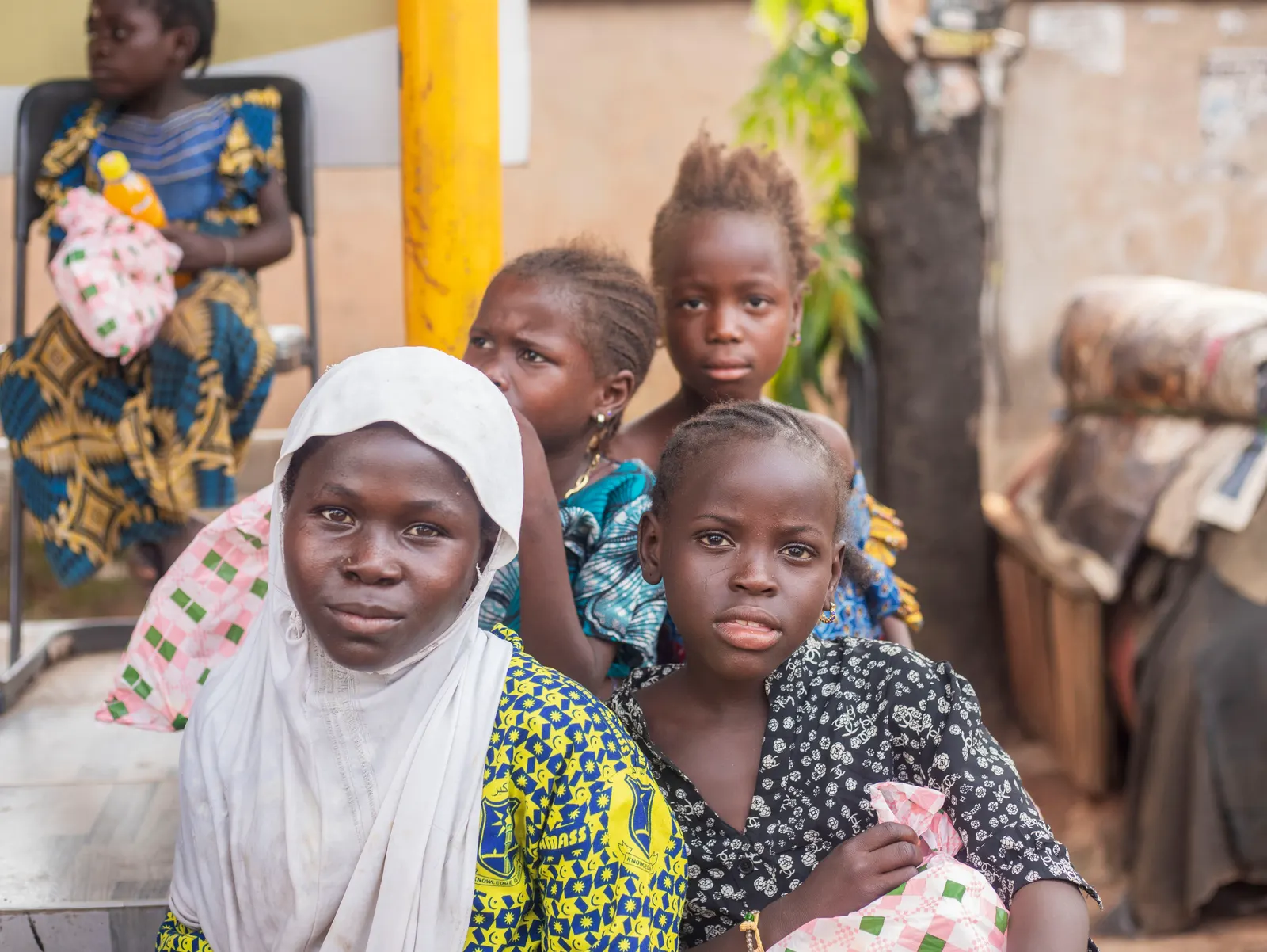 Mother in a white headscarf with her children holding food packages after a Joy to the Street relief distribution in Kumasi