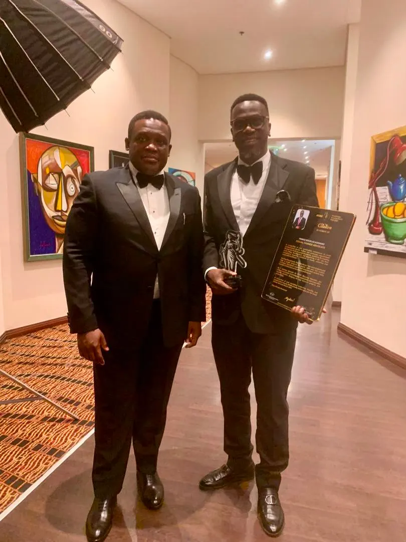 Prince Douglas Asamany holding the Social Change Advocate Award plaque