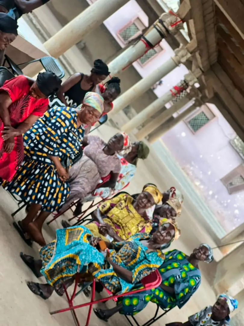 Women in colourful traditional dresses seated together at the gathering