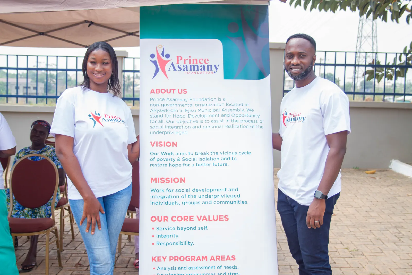 Foundation volunteers standing beside the foundation mission and vision banner during a community capacity-building event