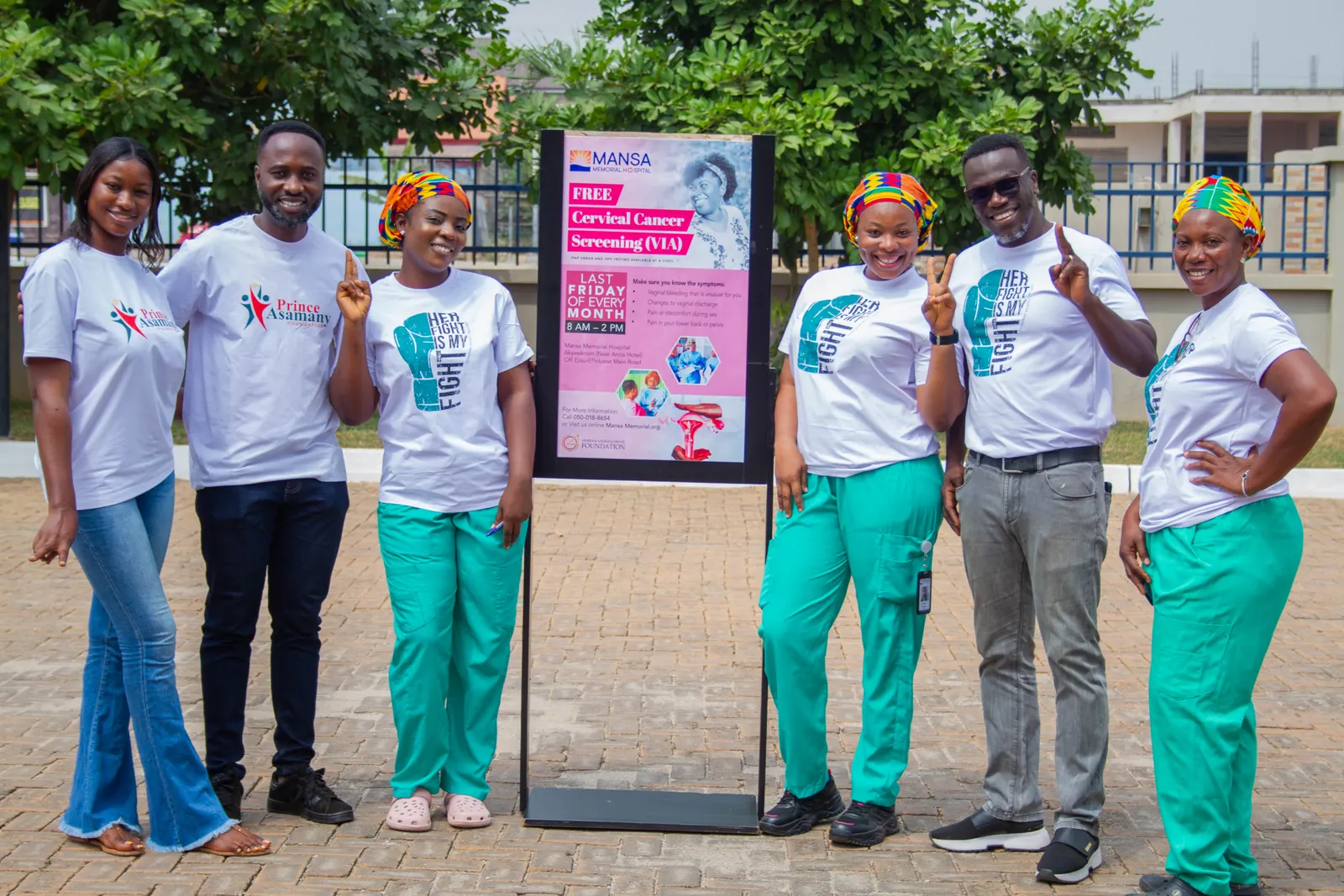 Health workers and foundation team posing by a free cervical cancer screening banner
